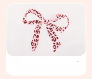 Detailed close-up of a leopard print bow pattern on high-quality white knit fabric