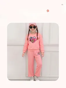 Detail of pink cotton girl set with heart patchwork sweatshirt and matching pants
