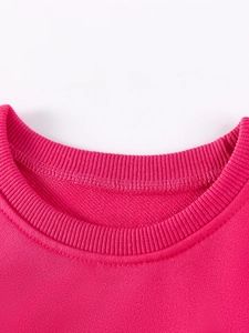 Gros plan du col rond côtelé d'un sweat-shirt à manches longues rose pour fille