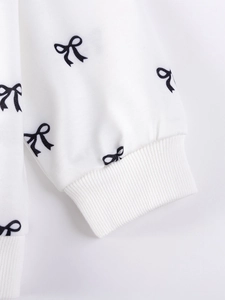 White long-sleeve cotton girl sweatshirt with black bow print and ribbed cuffs