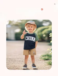 Outdoor shot of boys summer outfit with dark green tee and khaki shorts set