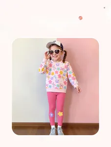 Dettaglio del set felpa rosa con fiori e leggings fucsia per bambina con decorazioni
