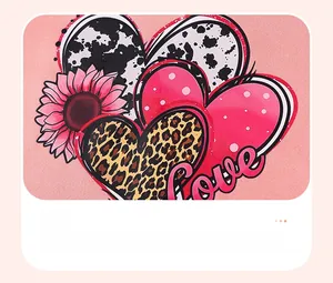 Detail of pink cotton fabric showing animal print heart graphics and Love embroidery