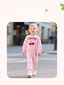 Close-up of pink toddler girl tracksuit featuring cherry prints and ribbed cuffs