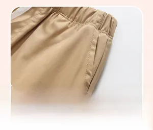Detail of khaki cotton shorts showing elastic waistband and functional side pockets