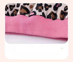 Detailed view of leopard print fabric with pink hearts and ribbed knit hem for kids' outfit