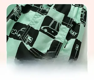 Dettaglio dei pantaloncini a scacchi verde menta con stampe di auto e tasche applicate