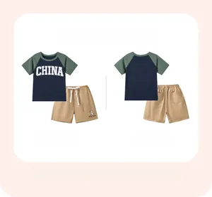 Detail view of boys' navy raglan T-shirt with CHINA print and khaki drawstring shorts