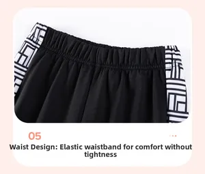 Close-up of boys' black tracksuit pants featuring elastic waistband and geometric side trim