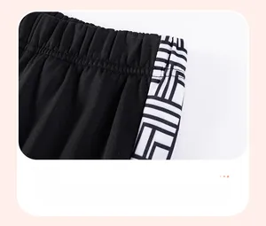Detail of boys' black sports joggers showing elastic waistband and geometric side print