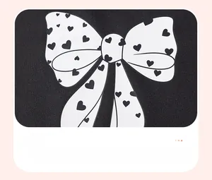 Close-up of heart print bow pattern on black knitted fabric for autumn kids' set