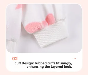Dettaglio dei polsini a costine su un set in pile bianco a pois rosa per bambina