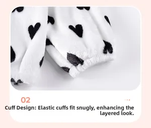 Dettaglio in tessuto peluche con cuori neri e polsini elastici per maglione da bambina