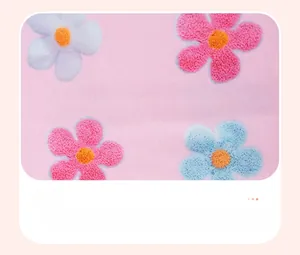 Close-up of pink cotton fabric featuring vibrant red and blue floral patterns for girls