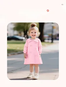 Dettaglio del vestito in cotone rosa a maniche lunghe con fiocchi decorativi e polsini