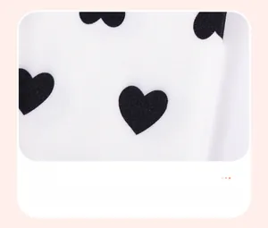 Detail of soft white cotton fabric with black heart print for baby girl clothing