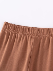 Détail de la taille élastique d'un pantalon d'automne pour fille en coton marron