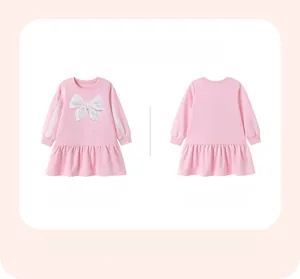 Détail à plat d'une robe rose à manches longues pour filles avec nœud blanc et jupe plissée