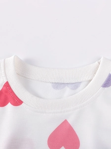Girl's white long sleeve sweatshirt featuring pink and purple heart print with ribbed neckline