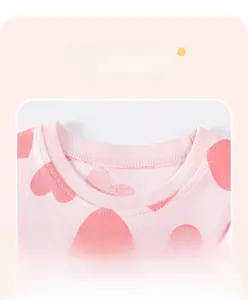 Detail of pink cotton girl's dress showing ribbed neckline and heart print pattern