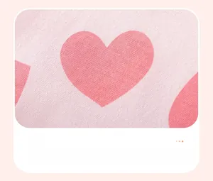 Detailed view of pink knitted cotton fabric with vibrant red heart pattern prints