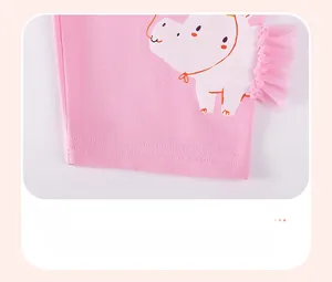 Détail du bas de short rose en coton avec écusson animal et bordure en dentelle tulle