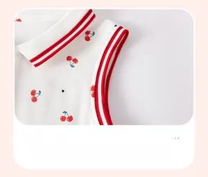 Détail de robe blanche pour fille avec motif cerise et poignets en tricot rayé rouge