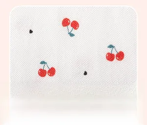 Détail du tissu gaufré blanc avec motifs mignons de cerises rouges et coeurs noirs