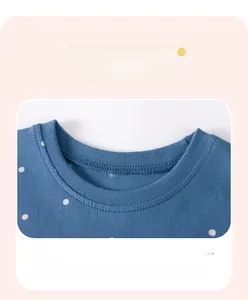 Dettaglio dello scollo rotondo e dei pois bianchi sull'abito in maglia blu scuro