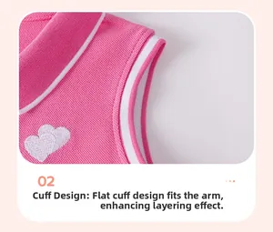 Detailed view of pink knitted dress sleeve with white heart embroidery and striped rib cuff