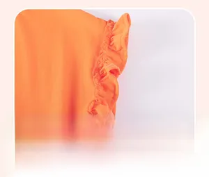 Gros plan détaillé des manches en coton orange avec un joli design à volants