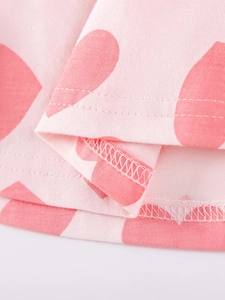 Pink cotton knit dress for girls featuring bright red heart patterns and neat stitching