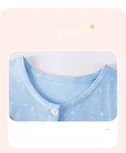 Détail d'une robe bleue à étoiles pour fille montrant le col et le bouton blanc