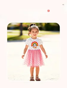 Détail de robe fille avec broderie arc-en-ciel et jupe en tulle rose à pois charmante