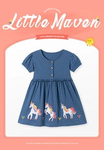 Détail de la broderie licorne et boutons en bois sur robe bleue à pois blancs