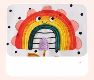Détail du patch arc-en-ciel thermocollant et motif à pois noirs sur la robe d'été pour fille