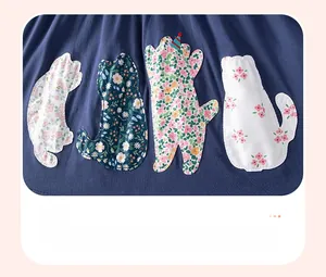 Détail d'appliqués chats fleuris mignons avec broderie fine sur robe d'été en coton bleu marine