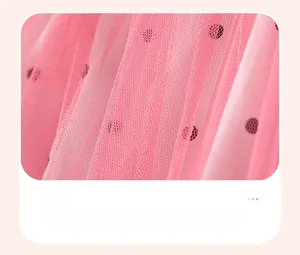 Gros plan d'une jupe en tulle rose à pois noirs et détails de maille plissée