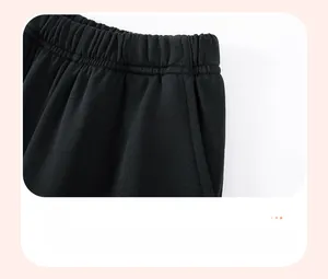 Detailed view of elastic waistband and functional side pockets on boys black cotton shorts