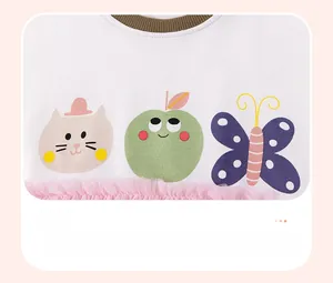 Detail of cotton girls dress featuring colorful cartoon prints and pink tulle hem decoration