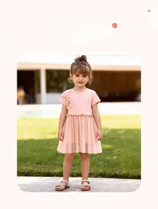 Détail de robe rose pour fille en tulle avec nœud décoratif et taille plissée à volants