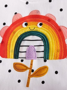 Polka dot girls dress featuring colorful rainbow smiley face flower patch embroidery detail