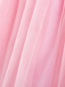 Dettaglio del tessuto a rete rosa di un vestito da bambina con strati di tulle morbido