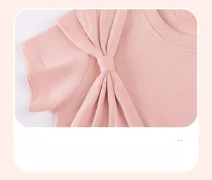 Détail d'une robe en coton rose avec un nœud décoratif sur l'épaule pour petite fille
