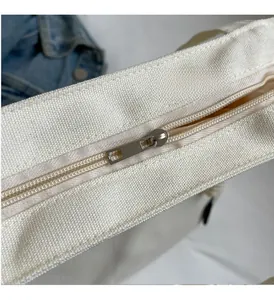 Macro shot of high-quality metal zipper closure and canvas texture on off-white tote bag