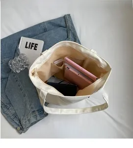 Spacious interior of canvas tote bag featuring inner pocket and smooth zipper closure