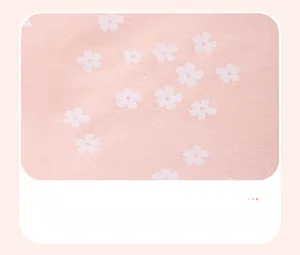 Dettaglio del tessuto in maglia di cotone rosa tenue con piccoli fiori bianchi stampati