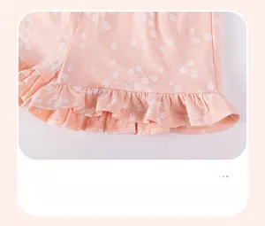 Dettaglio dei pantaloncini rosa a fiori con bordo a balze e motivi di fiori di ciliegio