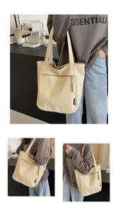 Detailed macro view of the front zipper pocket and woven puller on the beige canvas tote