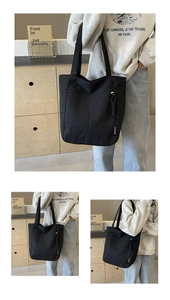 Detail of black canvas tote bag showing zipper pocket and fashion woven label